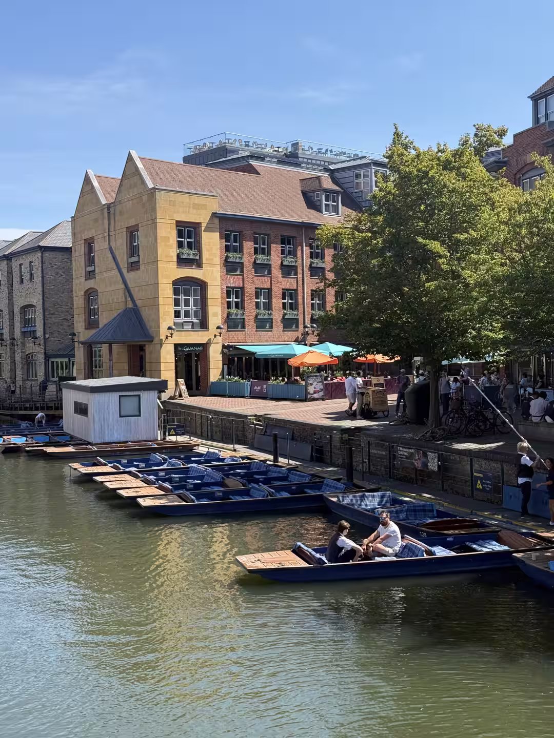 Punts and riverside buildings at a Cambridge punting station