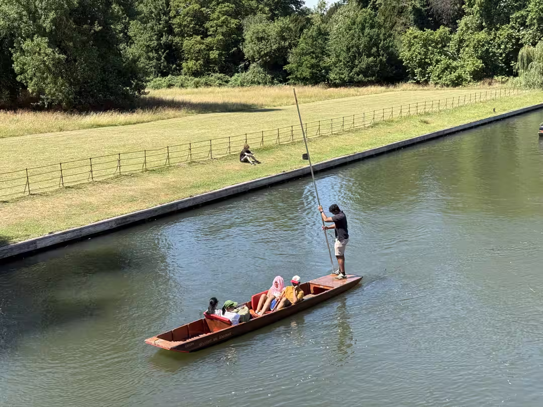 A chauffeur poling a punt with passengers on the River Cam, Cambridge