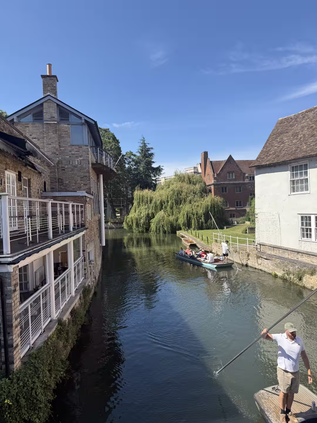 A chauffeur poling a shared punt on the River Cam, Cambridge